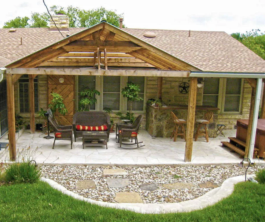 Covered patio with cedar pergola, stone flooring, and outdoor seating area